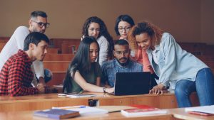 Professores e estudantes usando notebook em ambiente educacional, representando o uso responsável de inteligência artificial na educação. Foto: Vitaly Gariev/Unsplash.